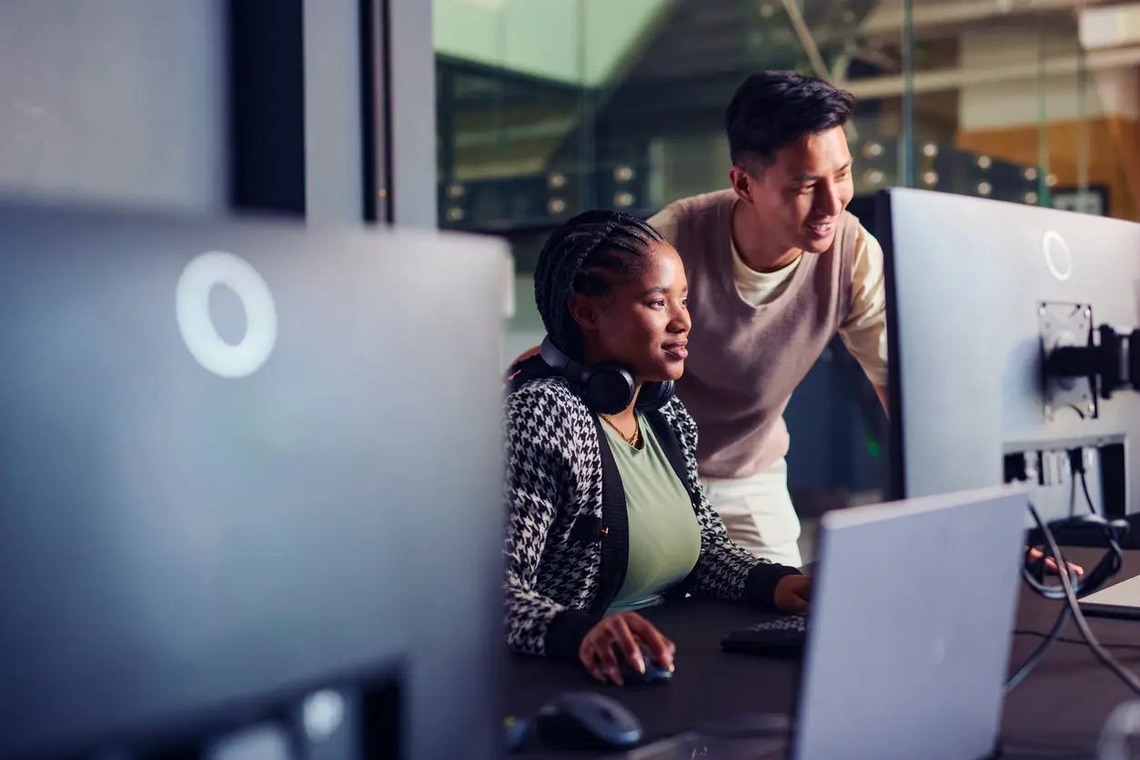 Young professionals working together at a computer.
