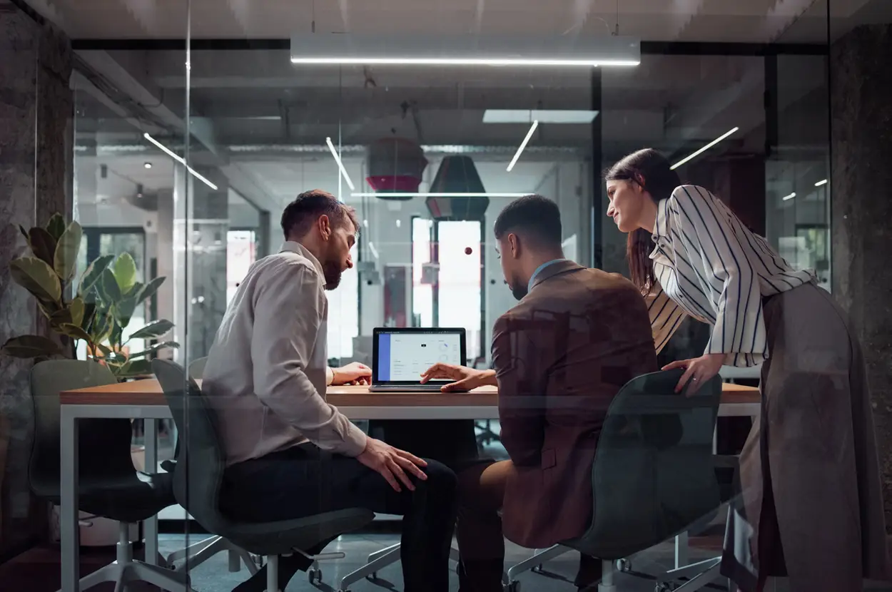 IT technician helping employees with a laptop.